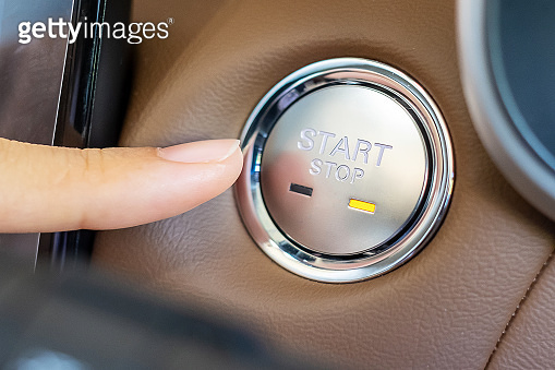 Finger press a car ignition button or START engine inside modern ...