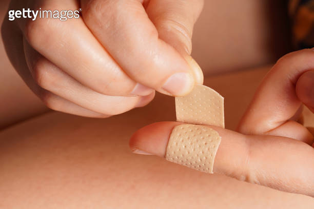 a girl puts a medical plaster on her finger 이미지 (1354375595) - 게티이미지뱅크