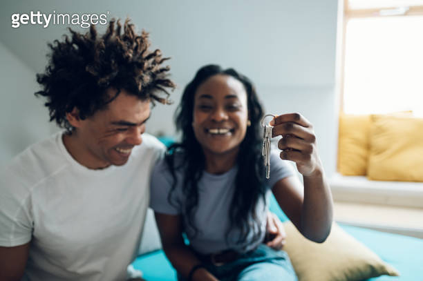 African american couple holding home keys in their new apartment 이미지 ...