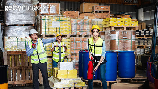 Group of warehouse worker holding a fire extinguisher for prepares for ...