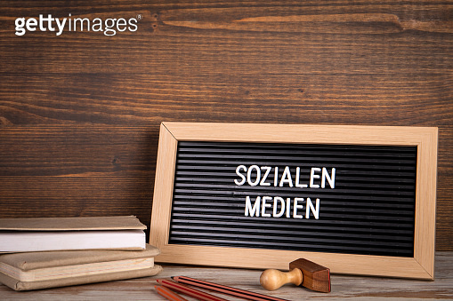 social-media-text-in-german-colored-pencils-and-a-stack-of-books-on