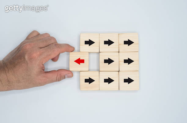 Concept of a wooden block with a red arrow pointing in one way and a ...