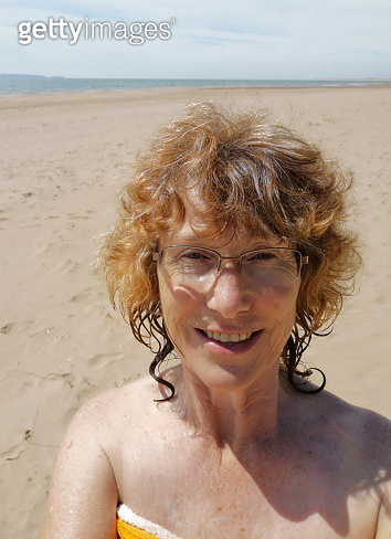 Mature Woman on the beach after a swim in the sea. 이미지 (1432782808