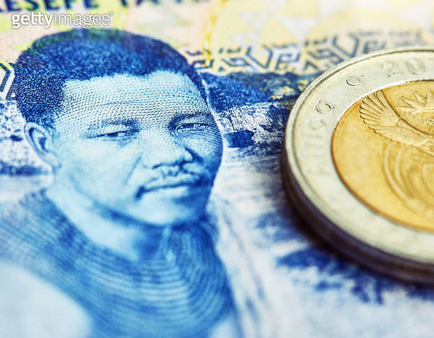 Close-up of South African R100 banknote and R5 coin, the note depicting ...