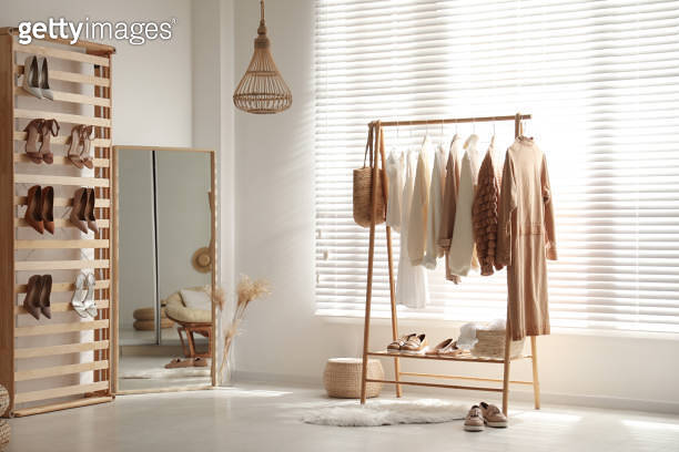 Modern dressing room interior with racks of stylish women's clothes and ...