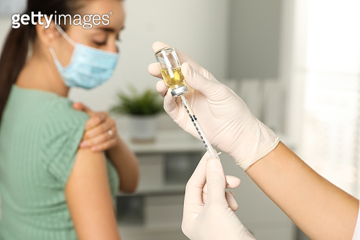 Daytime Injection Doctor giving injection to patient in hospital, closeup. Vaccination ...