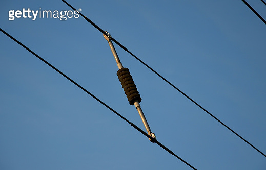 A spacer used to separate high voltage wires, held by a common corridor ...