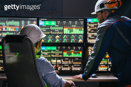 Group of engenners following production line using computer screens ...