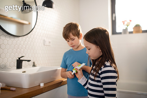 Little siblings brushing teeth in bathroom, morning routine concept