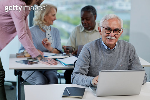 Retraining Class A senior woman is smiling while having a retraining class with a ...