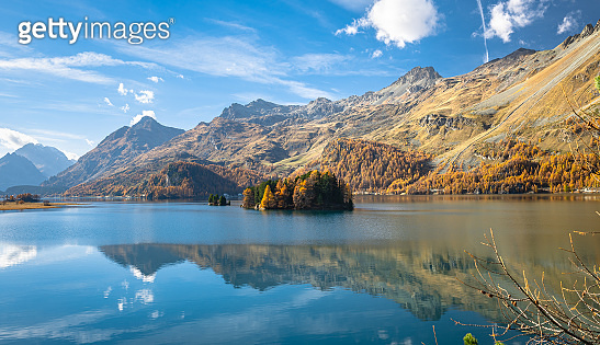 Beautiful reflections of mountains covered with golden larch trees in ...