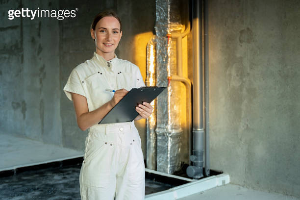 Designer builder with design project inspecting apartment, checks ...