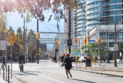 People running and riding bicycles on bike path on Queens Quay ...