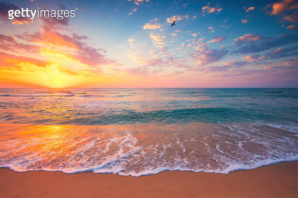 Scenic cloudscape over the sea waves and beach, color tropical sunrise ...