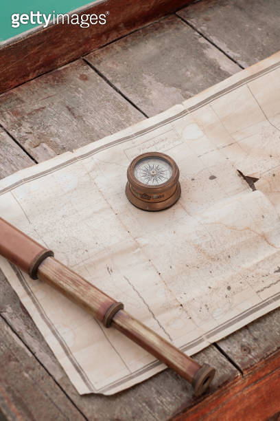 ancient nautical navigation equipment with compass, telescope and map ...