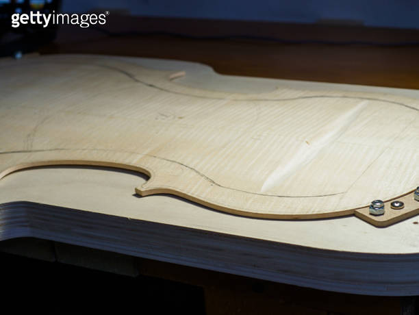 artisan luthier stringed instrument maker carve a spruce wood cello ...