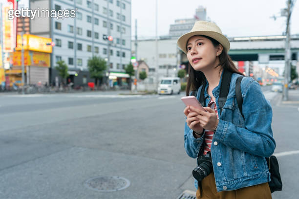 cheerful asian woman traveler using gps on mobile phone to search for ...