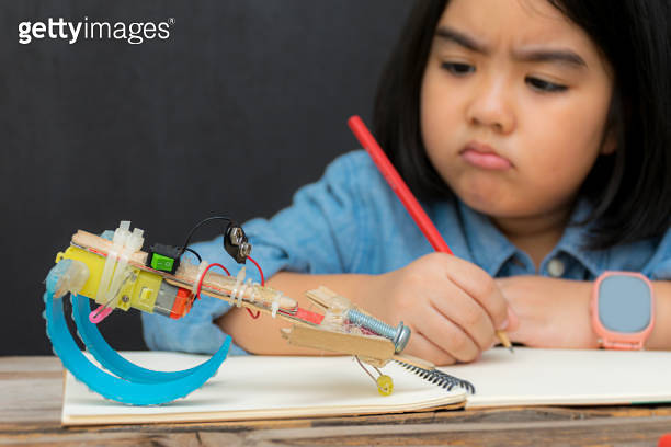 Fixing Science Setting right. Enthusiastic elementary school pupil fixing the robot ...