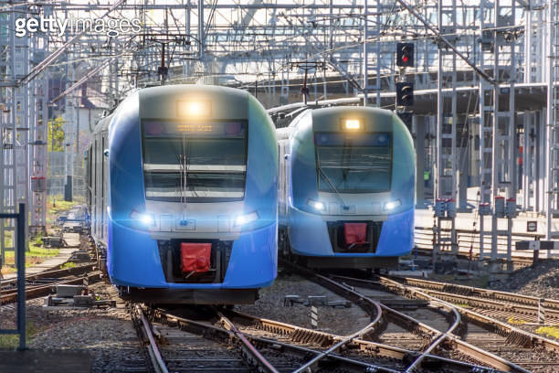 Two electric trains are traveling on parallel railway tracks with ...