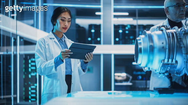 Middle Aged Engineer and Young Asian Scientist Collaborate on a New ...