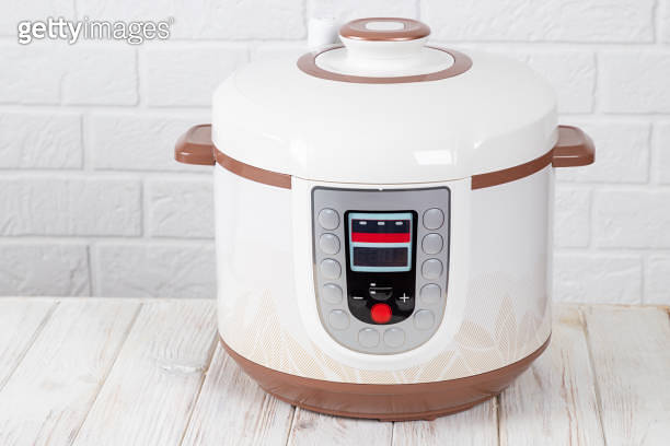 Table Cooker Electric Modern Electric Multi Cooker on a white wooden table in kitchen. Copy ...
