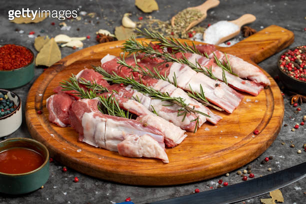 Fresh beef ribs. Pieces of raw beef ribs on a dark background. Butcher ...