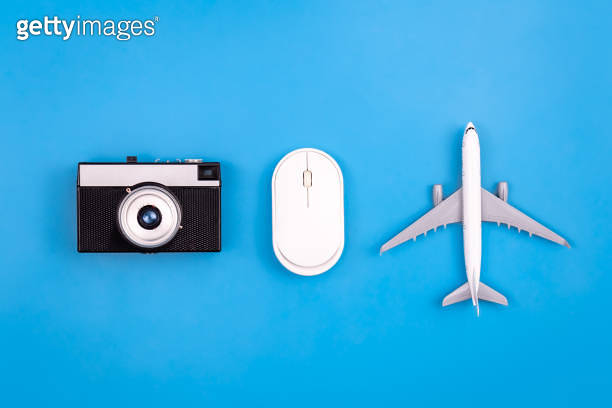 Vintage camera, computer mouse and airplane miniature on a blue ...