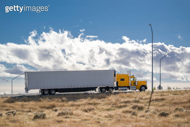 Side view of the yellow classic big rig semi truck with extended cab ...