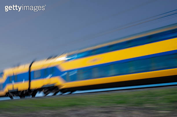 Train of the Dutch Railways driving through a rural landscape during ...