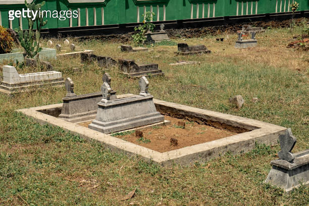 tombstones in a cemetery surrounded by a cement foundation 이미지 ...