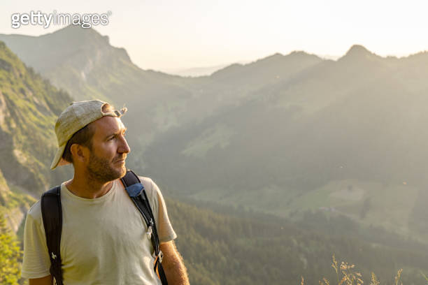 Man hikes along grassy mountain ridge at sunrise 이미지 (1727279809) - 게티이미지뱅크