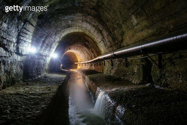 Underground vaulted urban sewer tunnel with dirty sewage 이미지
