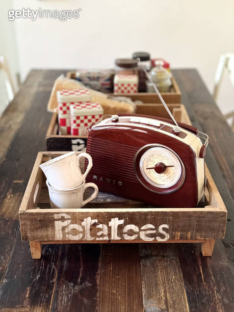 Radio in retro style and cups are in wooden kitchen boxes on a wooden ...