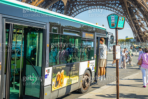 RATP bus parked in front of the Eiffel Tower on a sunny day in Paris ...