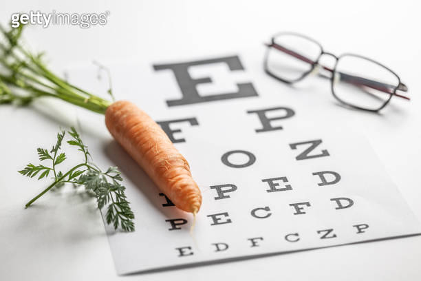 Fresh carrots as a source of vitamin A placed on the eye test chart ...