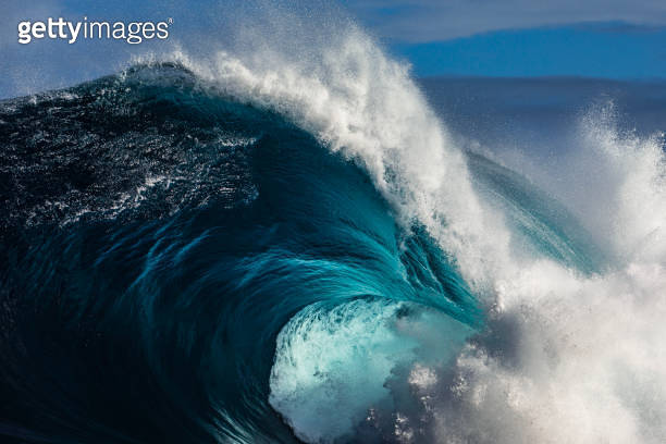 Close up to powerful blue wave breaking in the open ocean over a ...