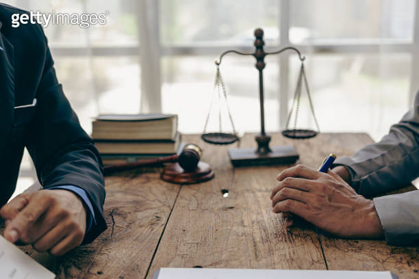 Lawyer working with client discussing contract documents with legal ...