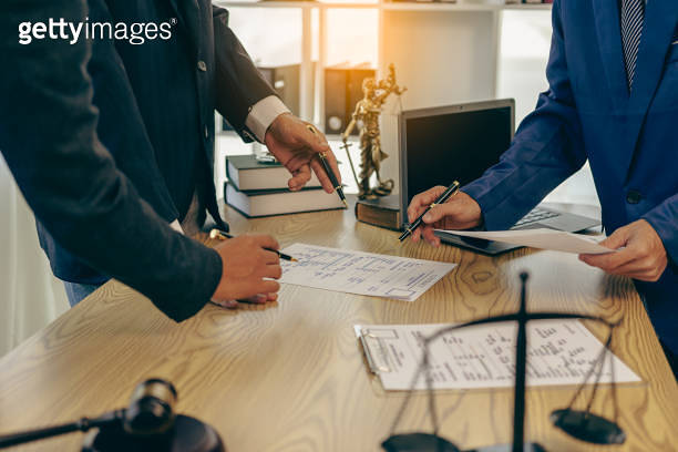 Lawyer working with client discussing contract documents with legal ...