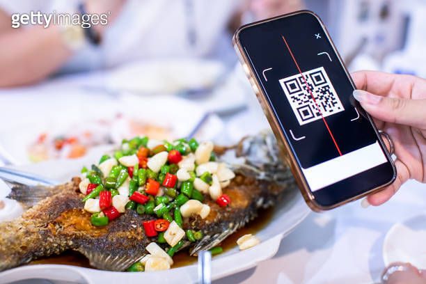 Selective focus to smartphone in hand to scan QR code on tag with ...