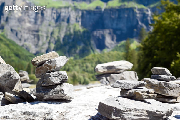 Stack of balancing rocks symbolising peace and mindfulness over a lush ...