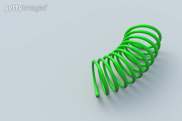 One curved metal spring on gray background. Flexibility wire. Twisted ...