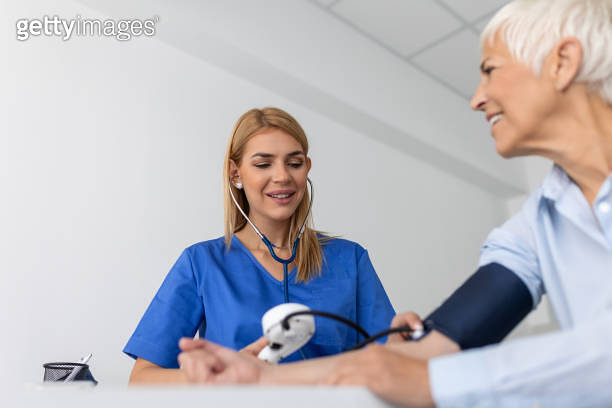 Measuring blood pressure. Senior woman have a visit with female doctor ...