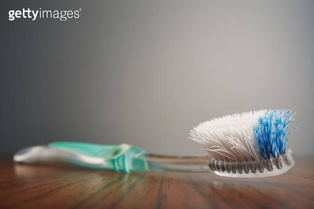 Worn out old plastic toothbrush used with bent bristles in bad ...