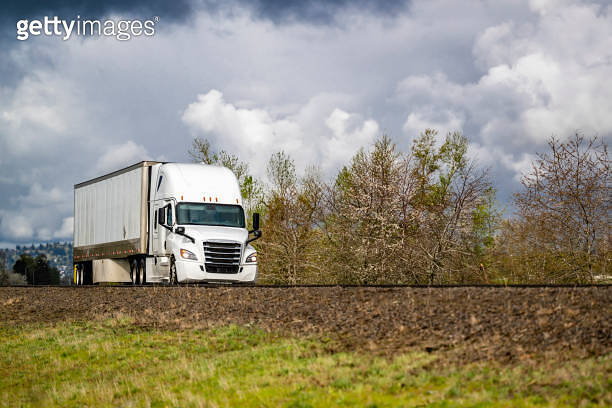 Popular white big rig semi truck transporting cargo in dry van semi ...