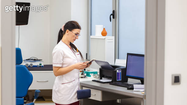 At the ENT clinic, nurse use app on mobile phone, to adjust medical ...