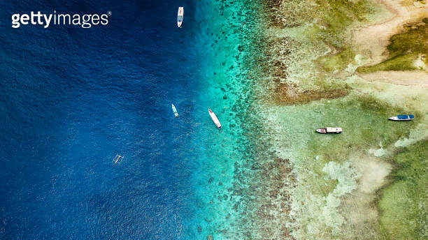Aerial view of traditional outrigger type boats with snorkelers and ...